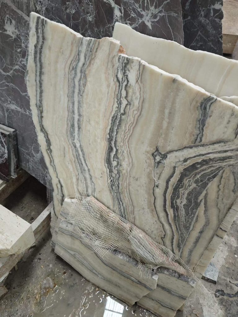 Cream and gray natural stone slab with layered dark veining